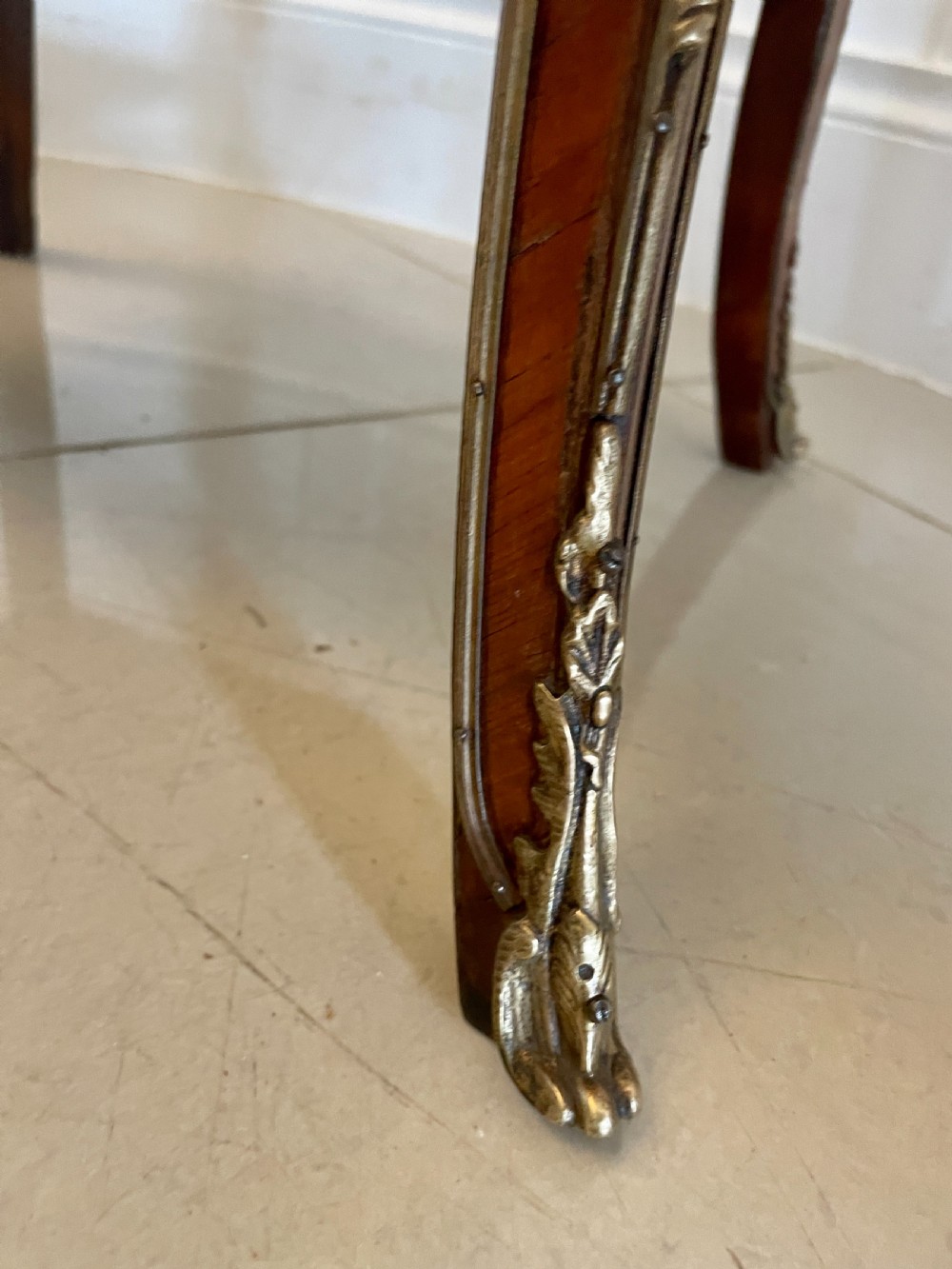 A French-style kingwood lamp table featuring geometric parquetry veneer, gilt-bronze ormolu mounts on cabriole legs, a pierced brass gallery rail, and an undertier shelf. View V