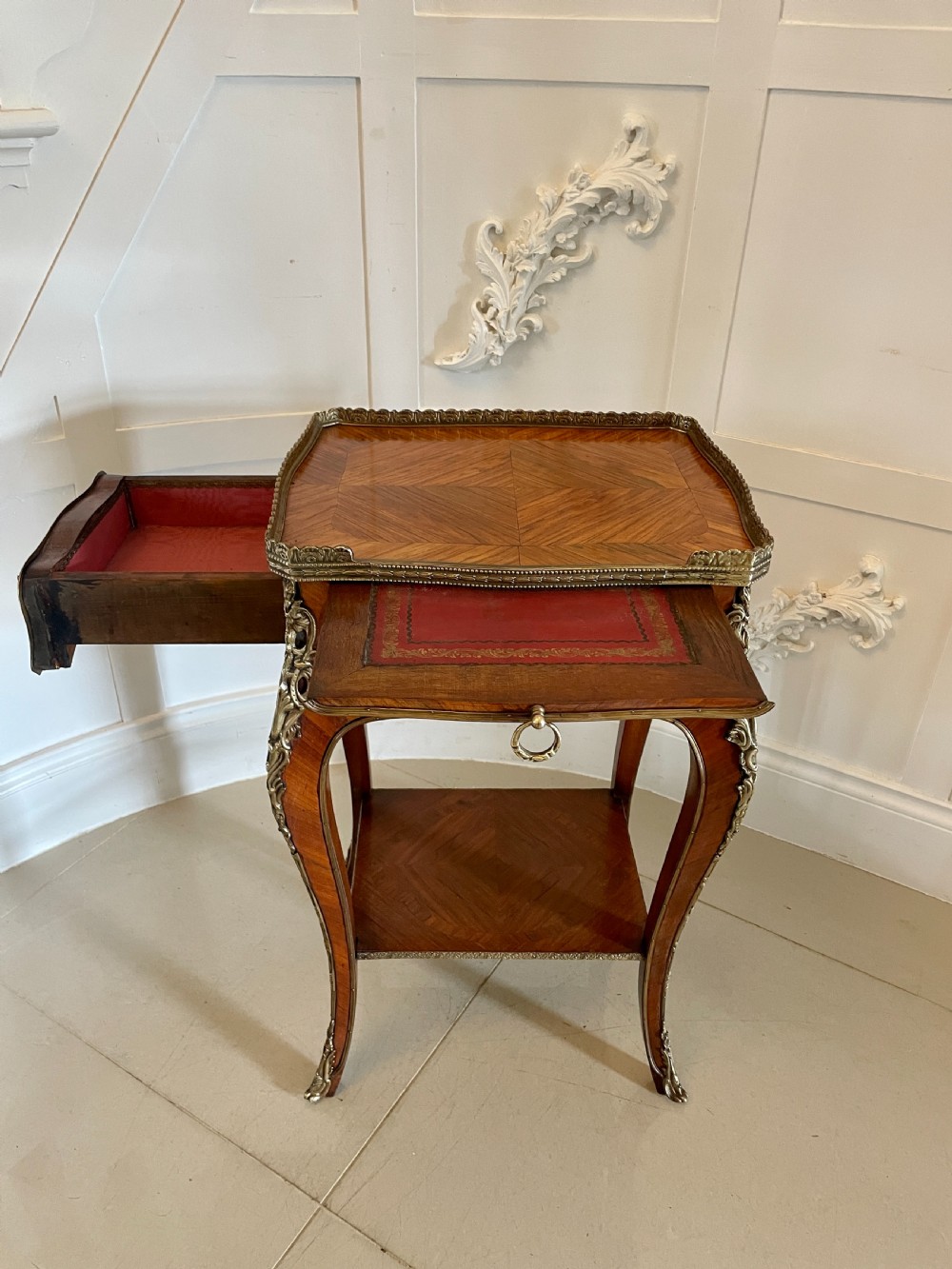 A French-style kingwood lamp table featuring geometric parquetry veneer, gilt-bronze ormolu mounts on cabriole legs, a pierced brass gallery rail, and an undertier shelf. View VI