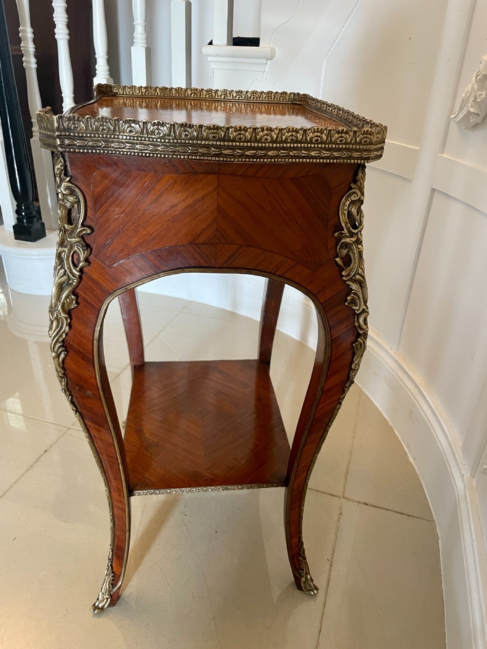 A French-style kingwood lamp table featuring geometric parquetry veneer, gilt-bronze ormolu mounts on cabriole legs, a pierced brass gallery rail, and an undertier shelf. View XII