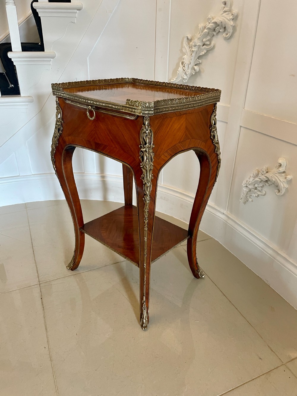 A French-style kingwood lamp table featuring geometric parquetry veneer, gilt-bronze ormolu mounts on cabriole legs, a pierced brass gallery rail, and an undertier shelf. View XIII