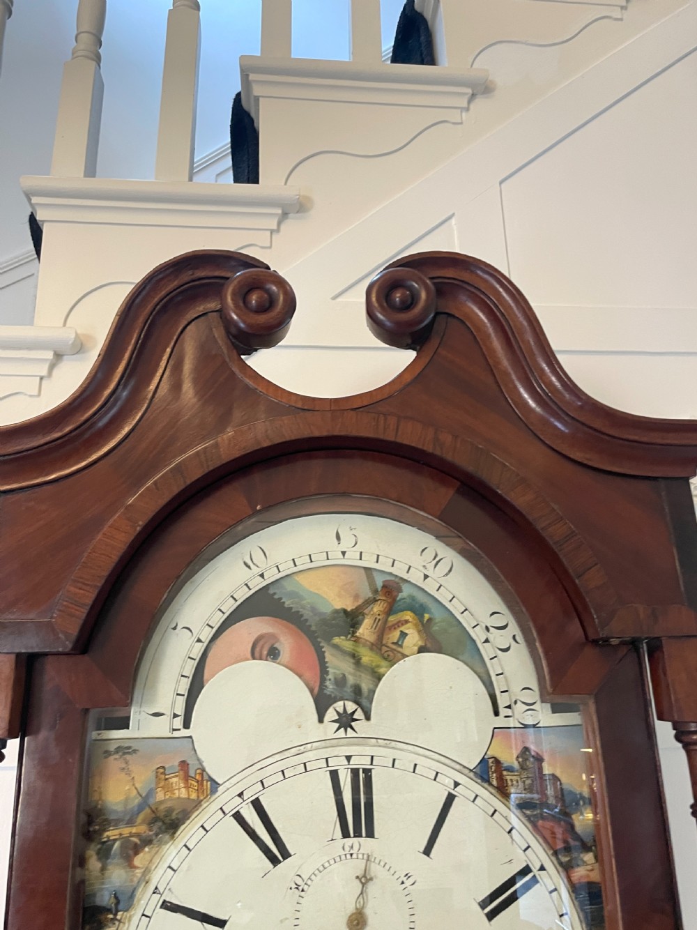 A George III mahogany eight-day longcase clock featuring a swan-neck pediment, turned hood columns, painted dial, and a shaped Gothic trunk door. View XIII