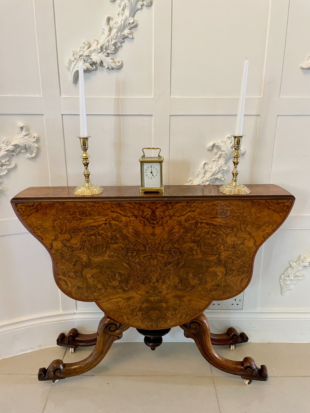 A pair of George III brass candlesticks featuring turned baluster stems and shaped scalloped bases. View II