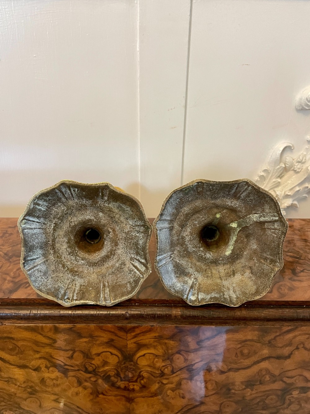 A pair of George III brass candlesticks featuring turned baluster stems and shaped scalloped bases. View VI
