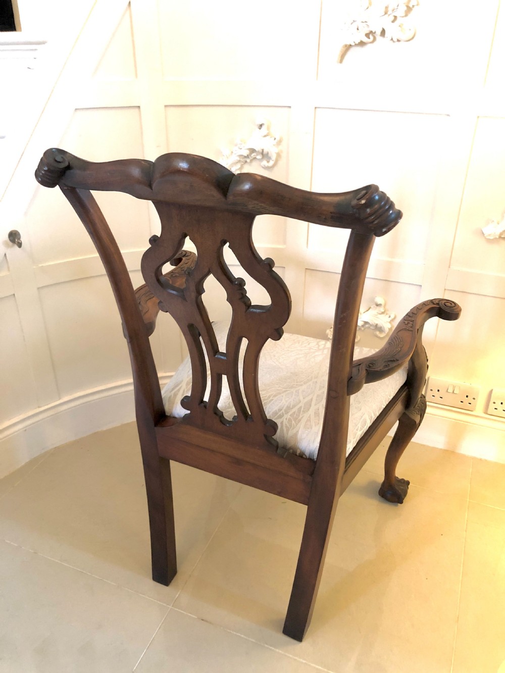 A carved mahogany Chippendale style desk armchair featuring a pierced back splat, scrolled armrests, light upholstered seat, and cabriole legs ending in ball and claw feet. View III