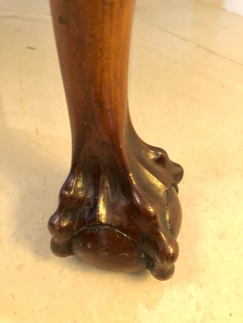 A carved mahogany Chippendale style desk armchair featuring a pierced back splat, scrolled armrests, light upholstered seat, and cabriole legs ending in ball and claw feet. View V