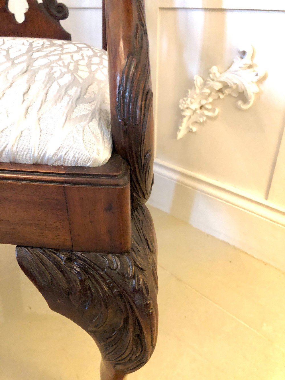 A carved mahogany Chippendale style desk armchair featuring a pierced back splat, scrolled armrests, light upholstered seat, and cabriole legs ending in ball and claw feet. View VI