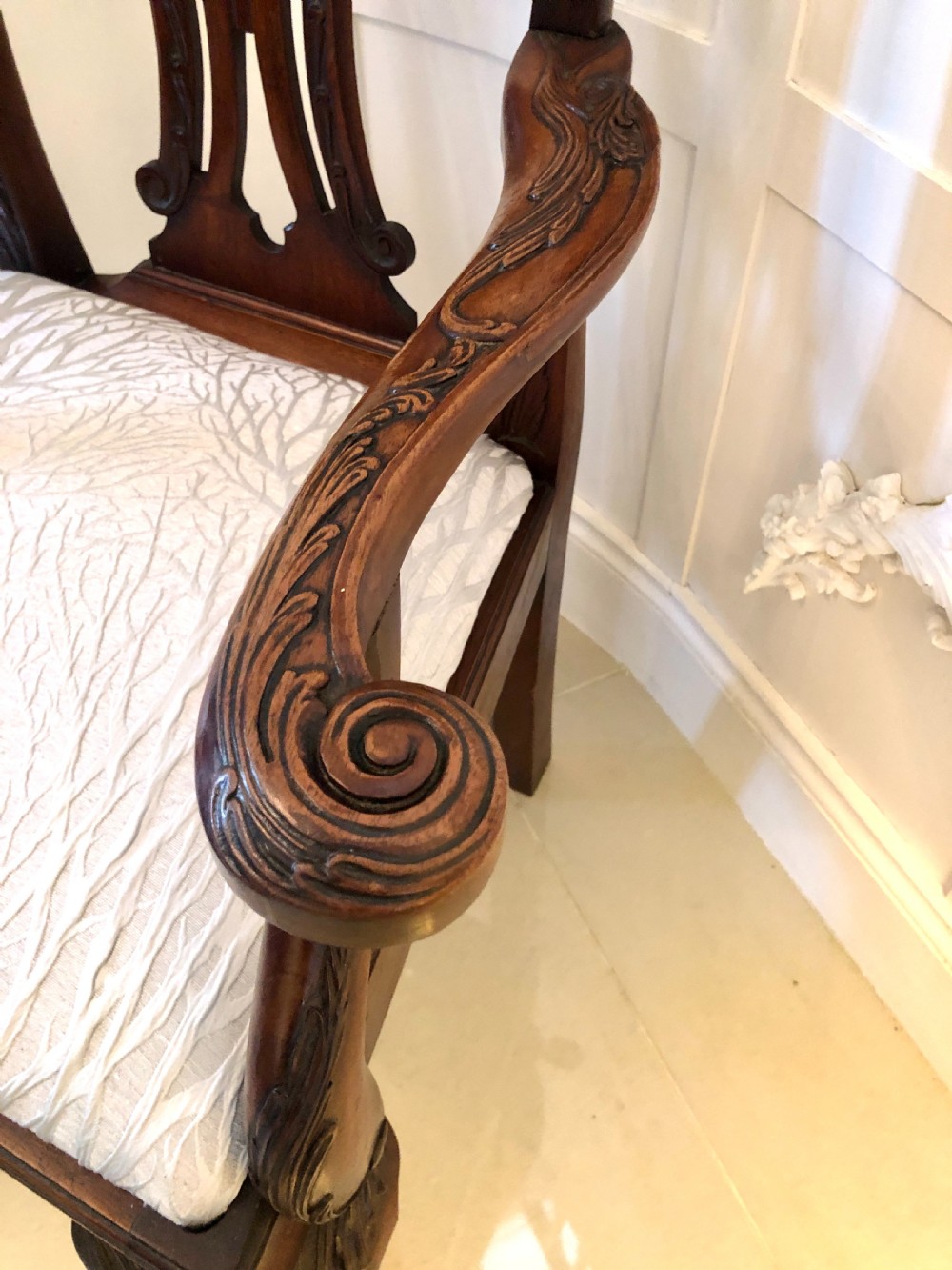 A carved mahogany Chippendale style desk armchair featuring a pierced back splat, scrolled armrests, light upholstered seat, and cabriole legs ending in ball and claw feet. View VII