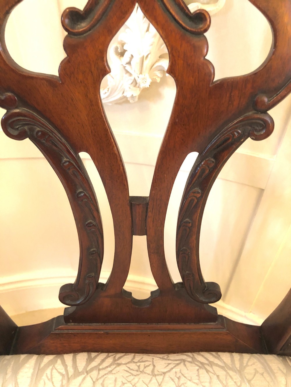 A carved mahogany Chippendale style desk armchair featuring a pierced back splat, scrolled armrests, light upholstered seat, and cabriole legs ending in ball and claw feet. View IX