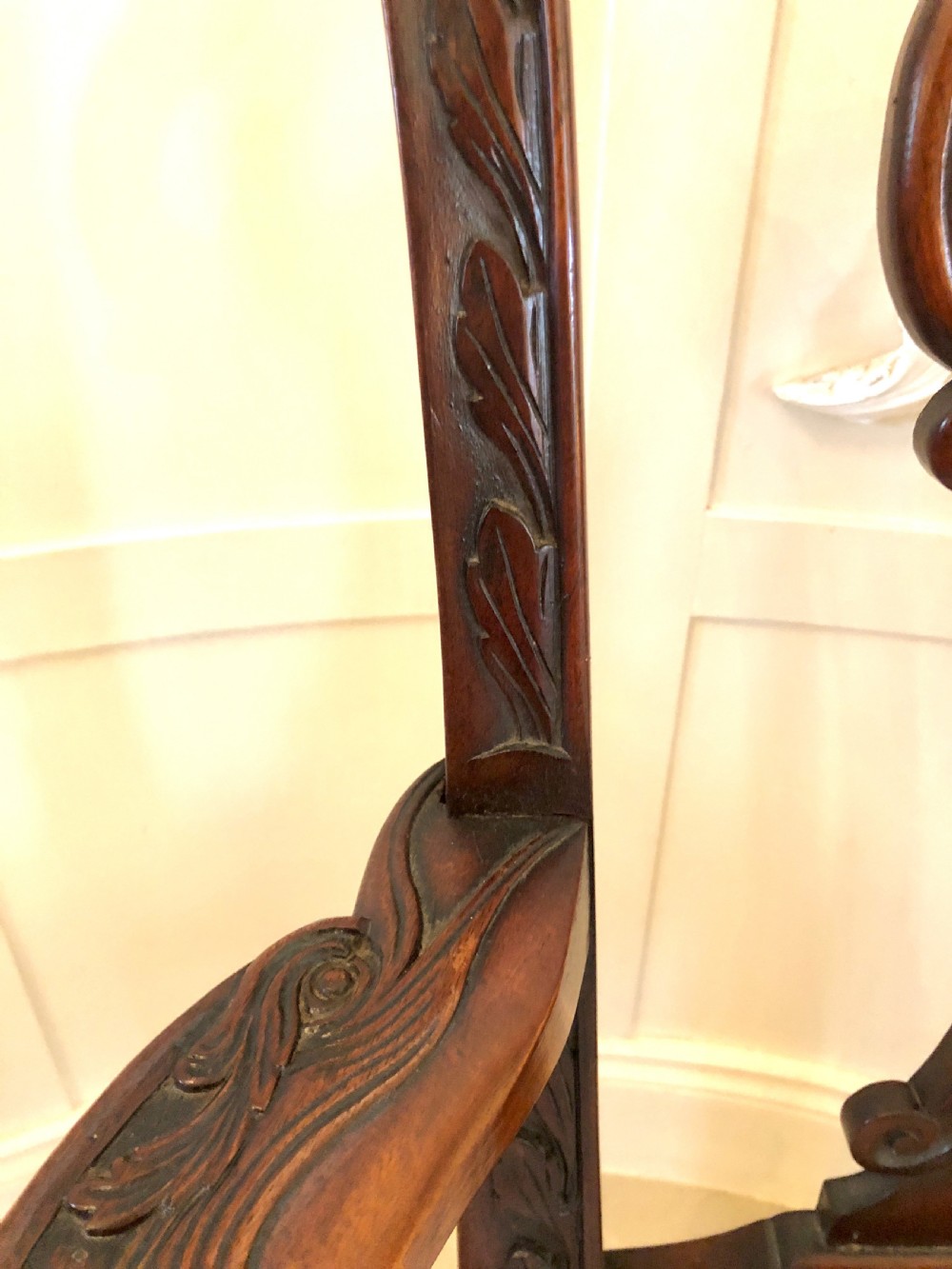 A carved mahogany Chippendale style desk armchair featuring a pierced back splat, scrolled armrests, light upholstered seat, and cabriole legs ending in ball and claw feet. View X