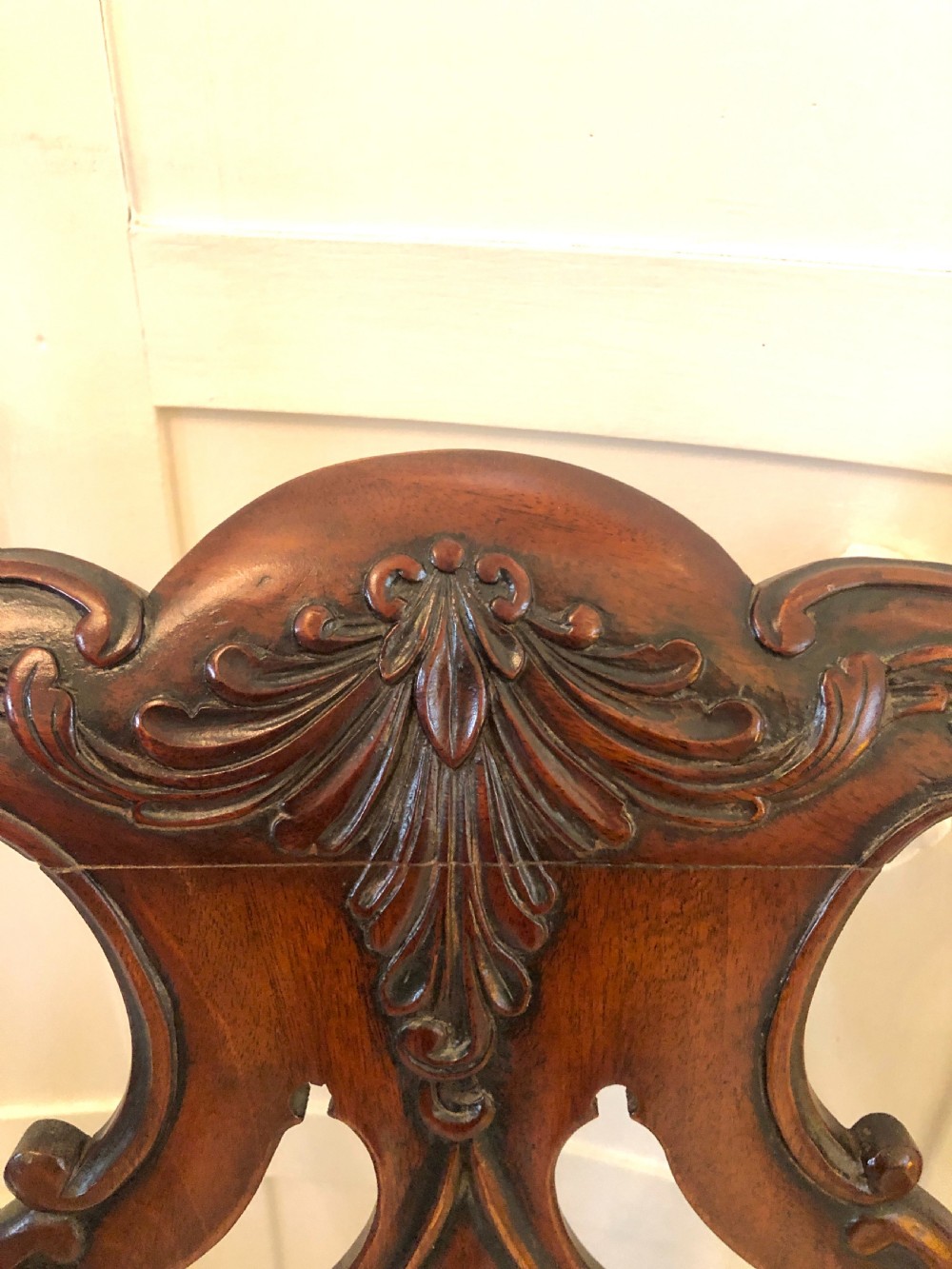 A carved mahogany Chippendale style desk armchair featuring a pierced back splat, scrolled armrests, light upholstered seat, and cabriole legs ending in ball and claw feet. View XI