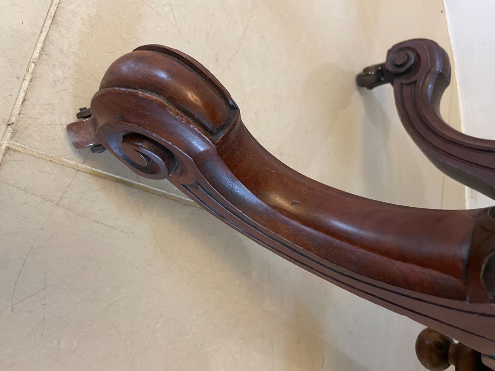 An antique Victorian oval centre table featuring book-matched burr walnut veneer with intricate floral inlay, supported by a carved central pedestal and four splayed legs on castors. View VI