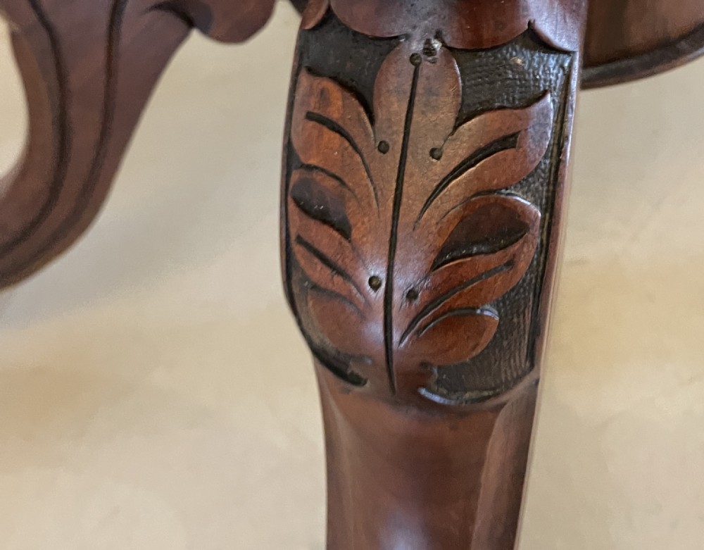An antique Victorian oval centre table featuring book-matched burr walnut veneer with intricate floral inlay, supported by a carved central pedestal and four splayed legs on castors. View VII
