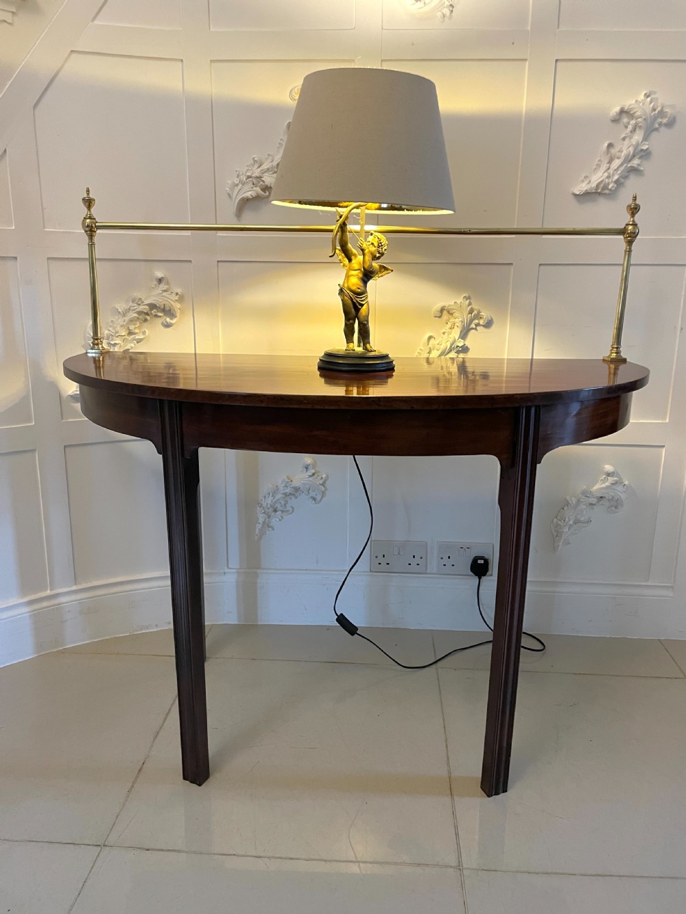 A pair of antique George III mahogany demi-lune console tables featuring raised brass gallery rails and square tapered legs. View III