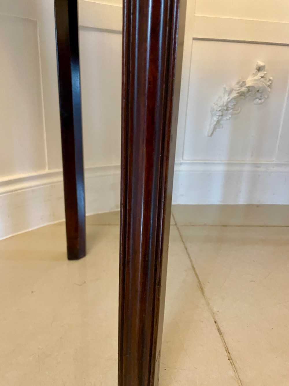 A pair of antique George III mahogany demi-lune console tables featuring raised brass gallery rails and square tapered legs. View V