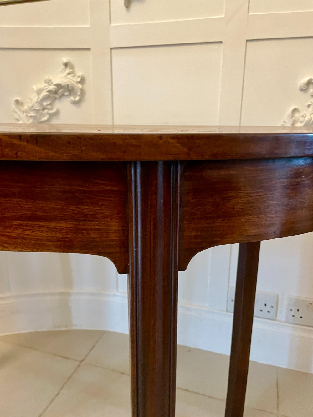 A pair of antique George III mahogany demi-lune console tables featuring raised brass gallery rails and square tapered legs. View VI
