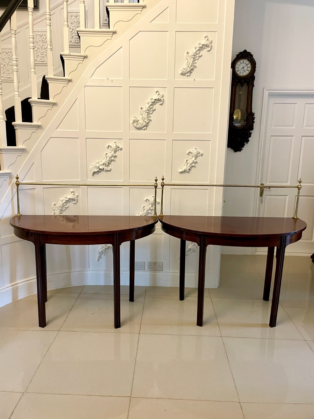 A pair of antique George III mahogany demi-lune console tables featuring raised brass gallery rails and square tapered legs. View VIII