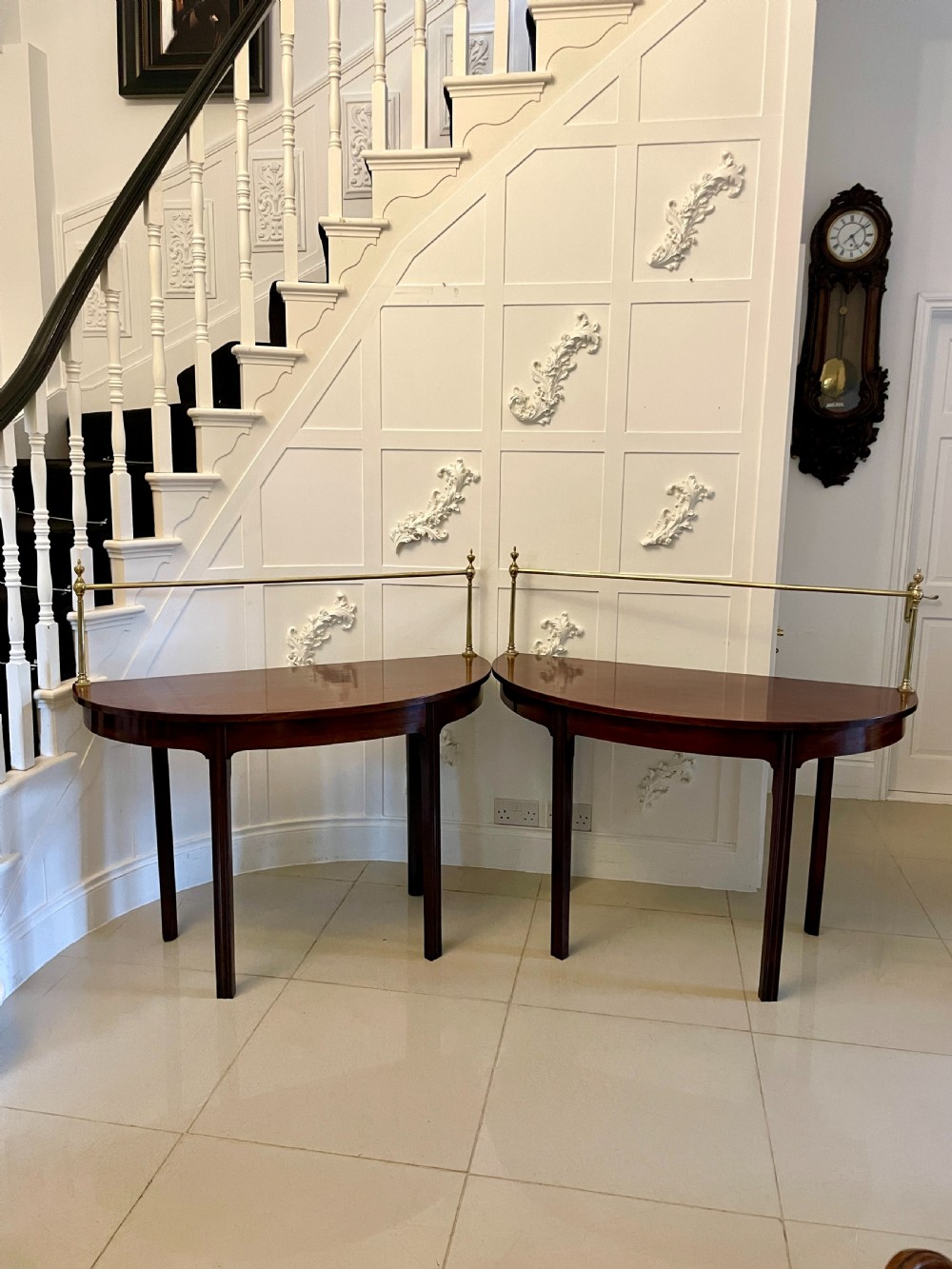 A pair of antique George III mahogany demi-lune console tables featuring raised brass gallery rails and square tapered legs. View IX