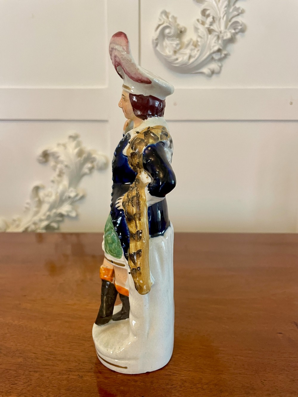 A Victorian Staffordshire earthenware flatback figure depicting a male standing character with a bird perched on his gloved hand, decorated in blue, green, orange, and white enamels. View VII