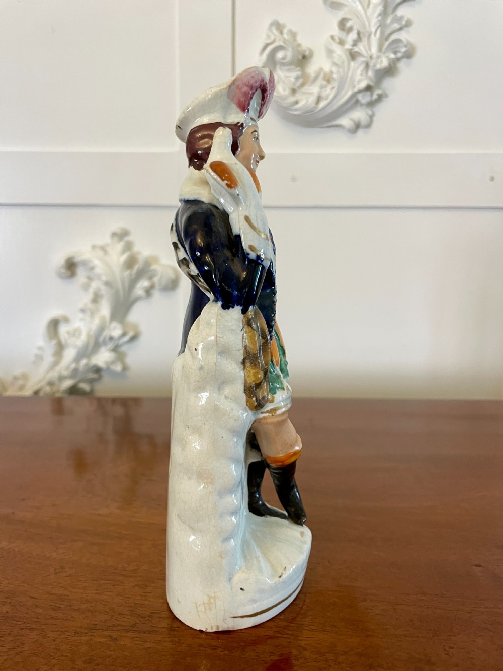 A Victorian Staffordshire earthenware flatback figure depicting a male standing character with a bird perched on his gloved hand, decorated in blue, green, orange, and white enamels. View VIII