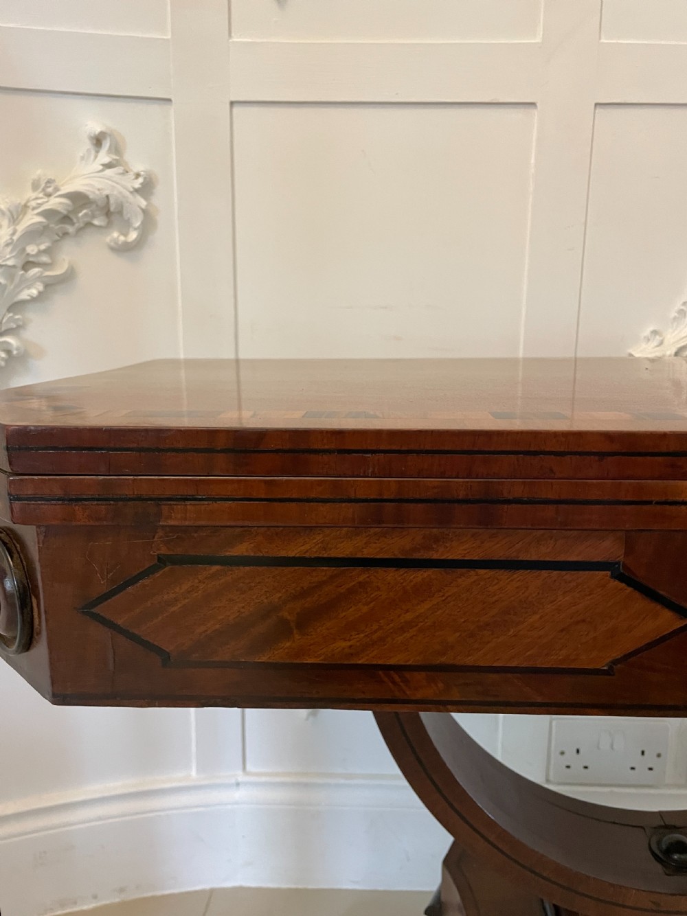 A Regency mahogany fold-over card table featuring crossbanded inlay, a central pedestal base, and four splayed legs with brass paw castors. View XI