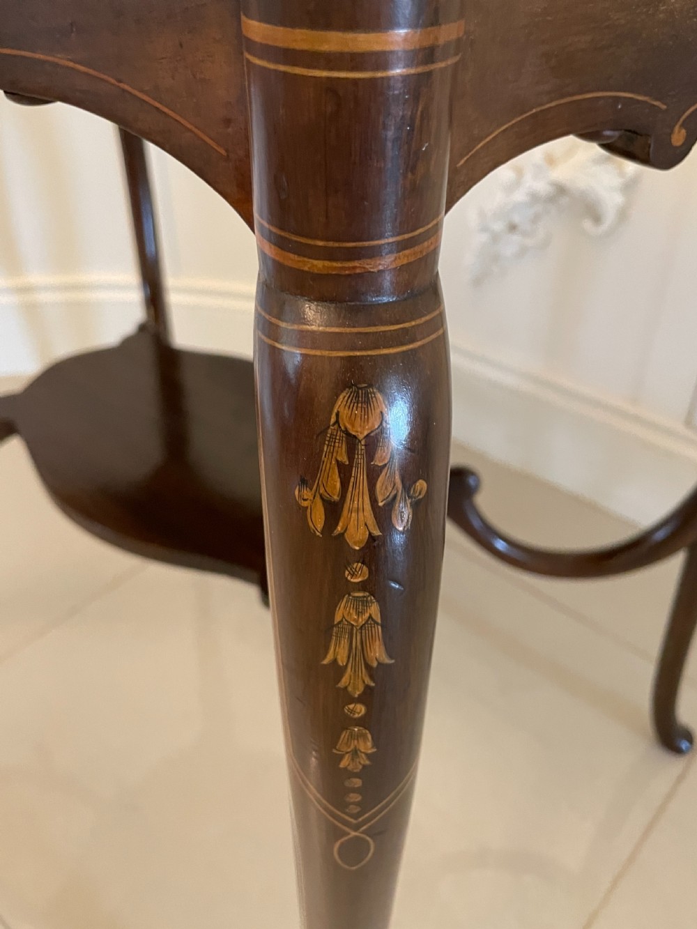 A Victorian mahogany centre table featuring a shaped serpentine top with floral marquetry inlay, slender cabriole legs, and a lower undertier. View VII
