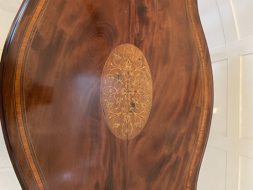 A Victorian mahogany centre table featuring a shaped serpentine top with floral marquetry inlay, slender cabriole legs, and a lower undertier. View IX