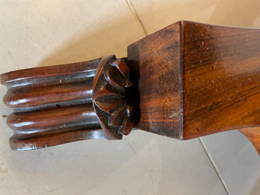 A Victorian rosewood fold-over card table featuring a turned central pedestal, carved frieze, and a quadform base with scroll feet. View VII