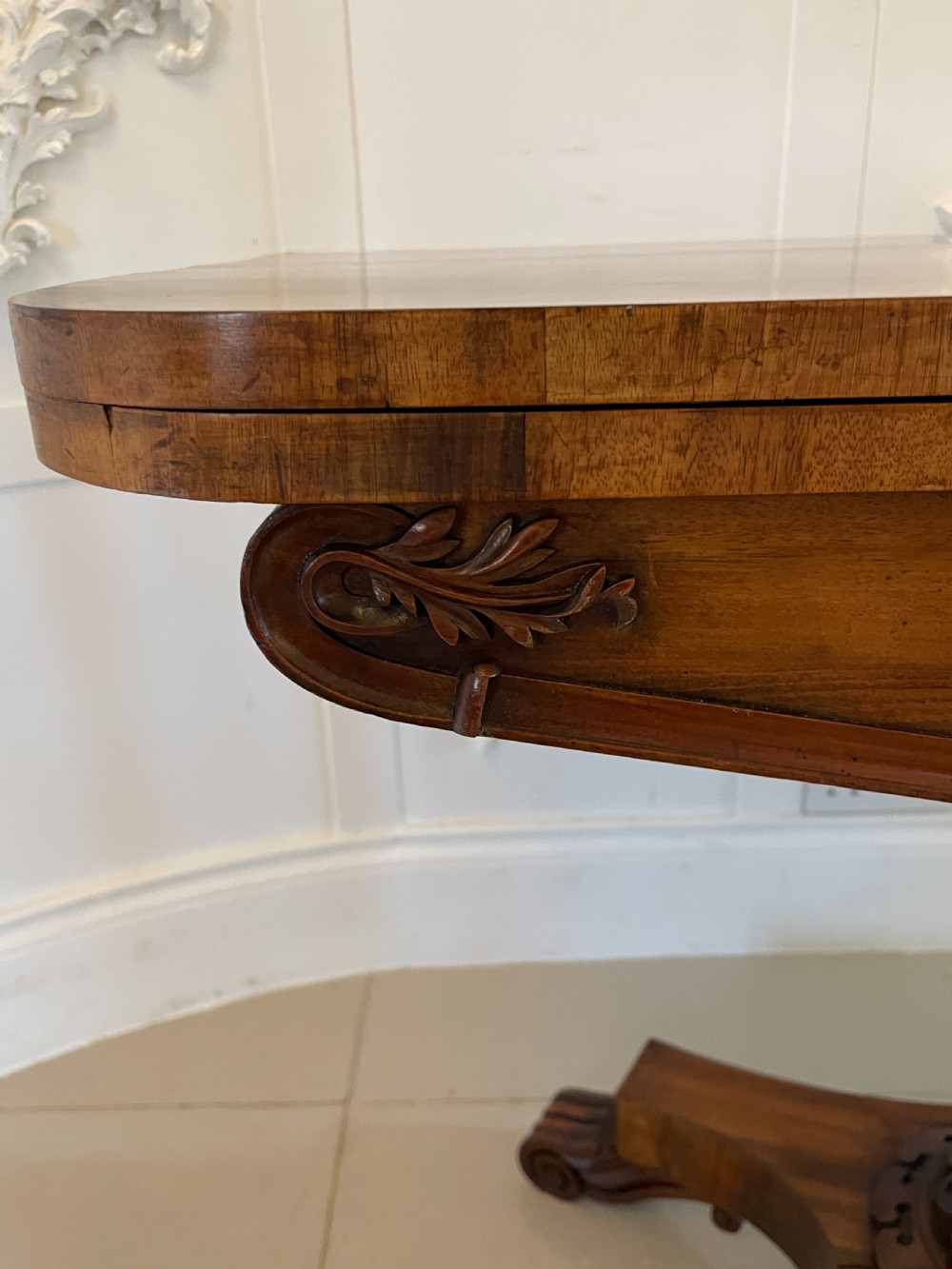A Victorian rosewood fold-over card table featuring a turned central pedestal, carved frieze, and a quadform base with scroll feet. View XIII