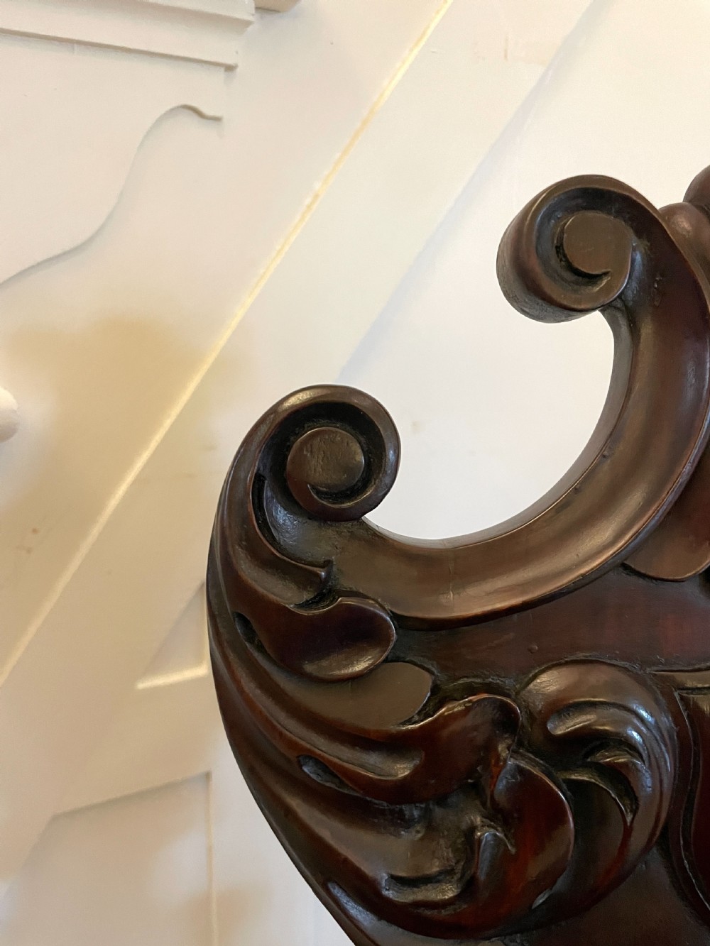 A pair of dark mahogany Regency hall chairs featuring intricate carved cartouche backs, shaped solid wooden seats, and turned, reeded front legs. View VI