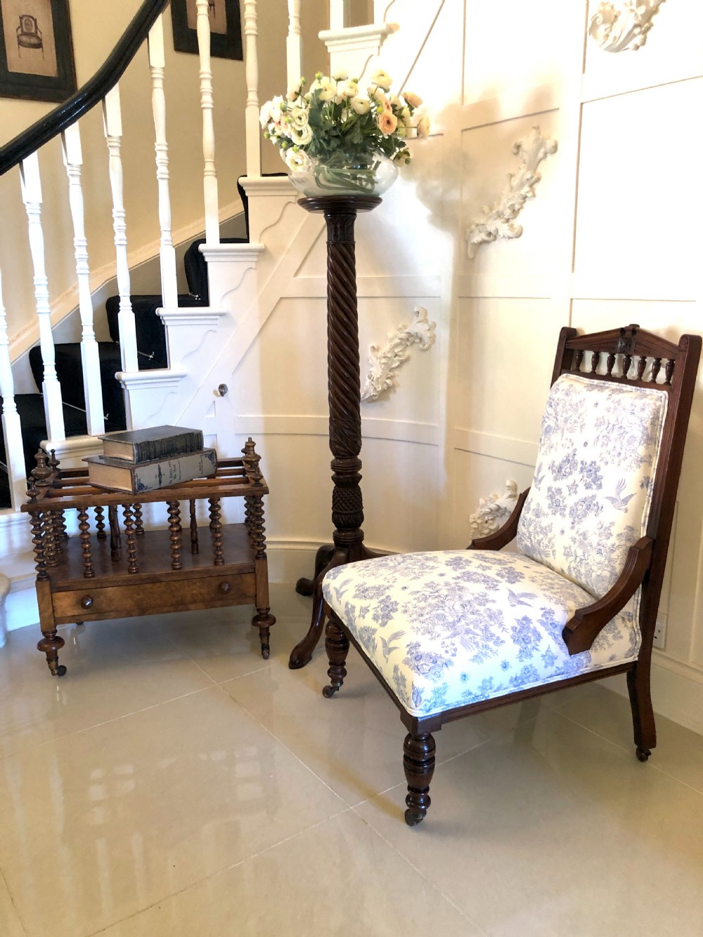 A Victorian carved walnut ladies chair featuring blue and white floral fabric upholstery, turned front legs with castors, and a spindle crest rail. View III