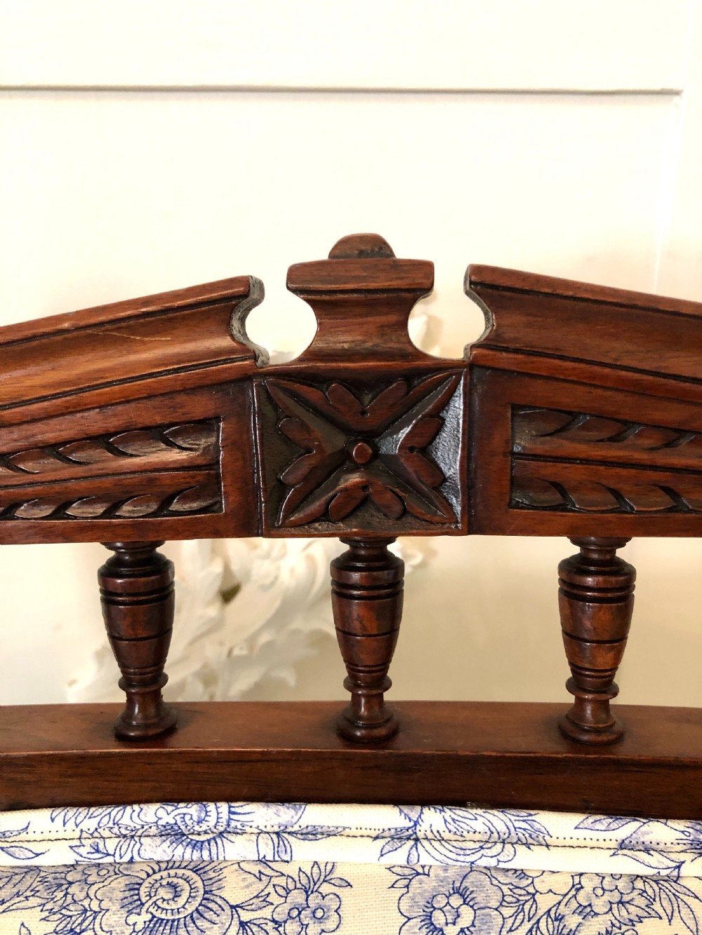 A Victorian carved walnut ladies chair featuring blue and white floral fabric upholstery, turned front legs with castors, and a spindle crest rail. View IX