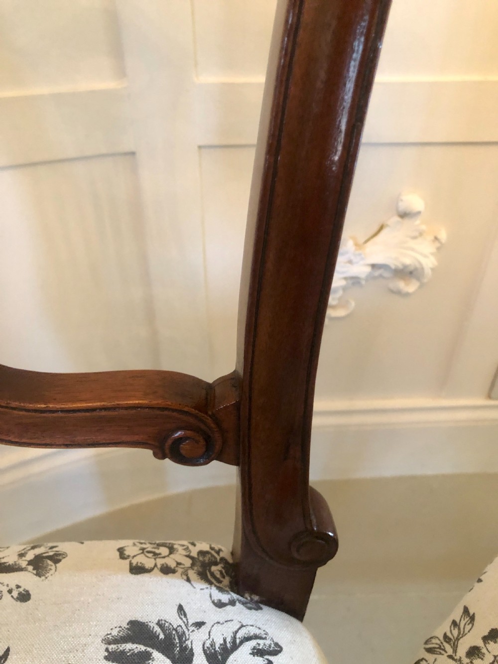 A set of four dark mahogany Victorian dining chairs featuring openwork carved back splats, cabriole front legs, and seats upholstered in a monochrome floral fabric. View VIII