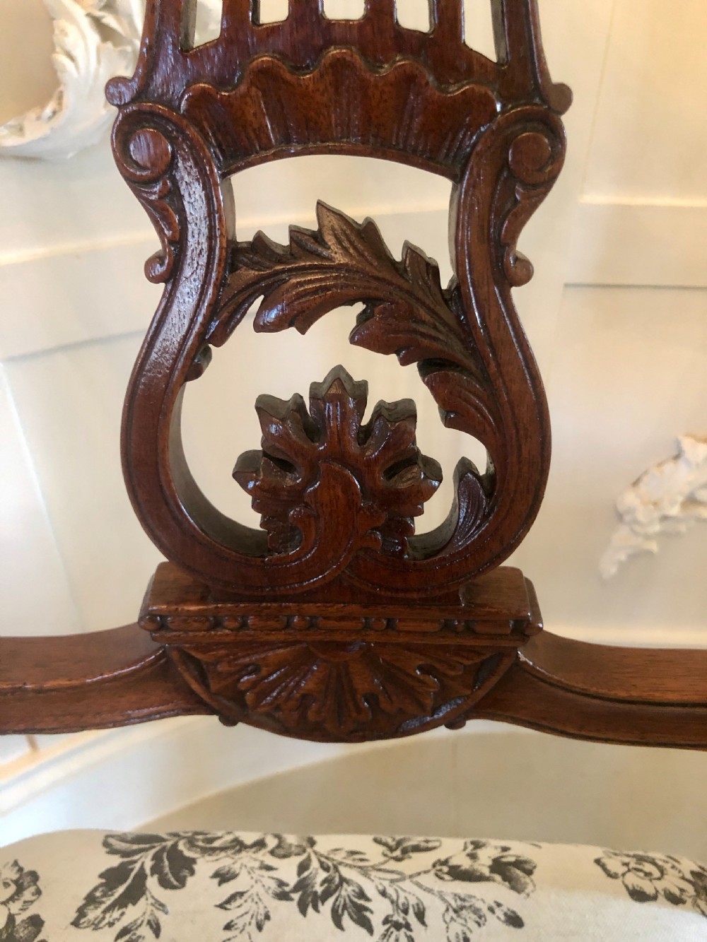 A set of four dark mahogany Victorian dining chairs featuring openwork carved back splats, cabriole front legs, and seats upholstered in a monochrome floral fabric. View IX