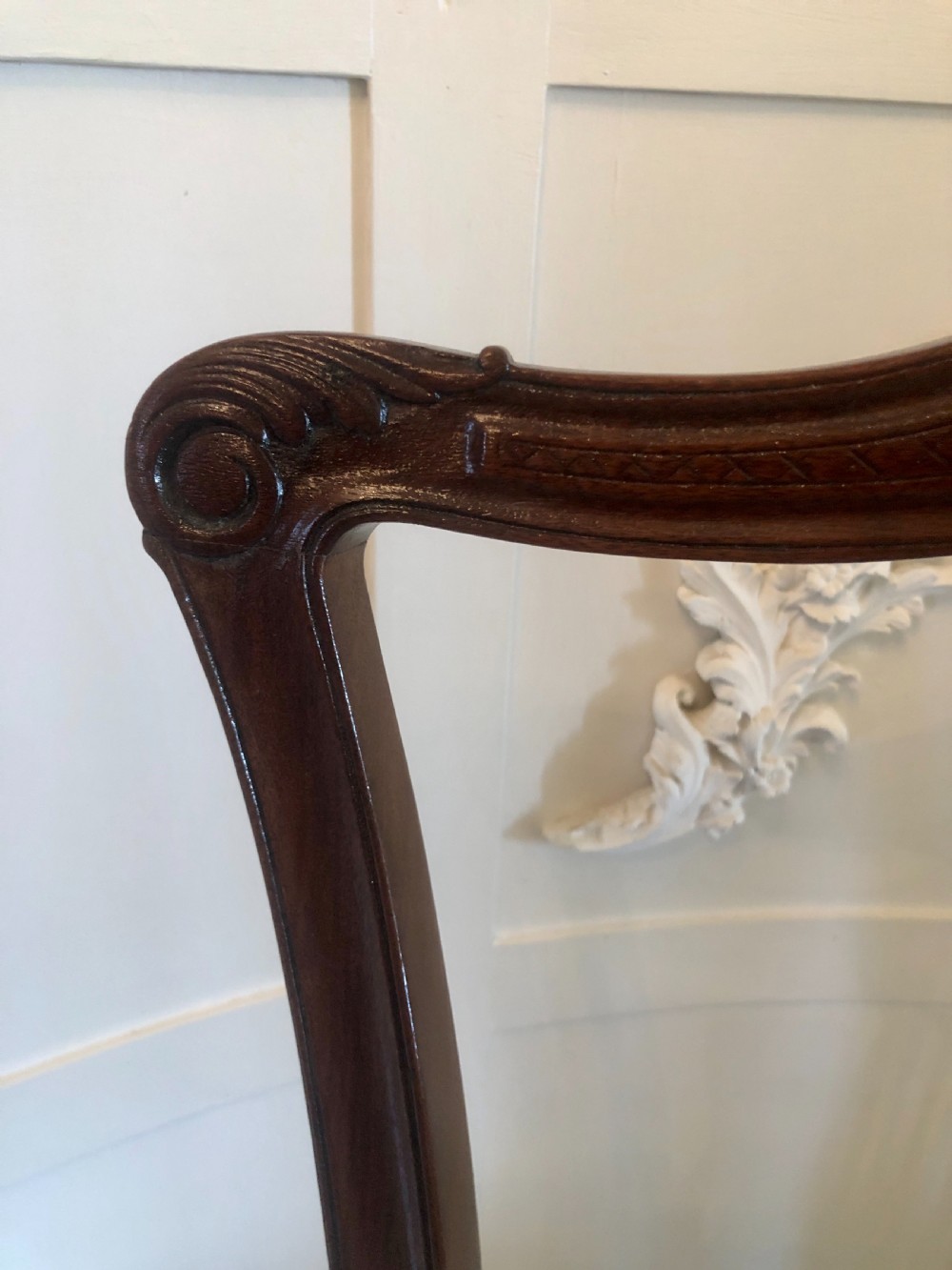 A set of four dark mahogany Victorian dining chairs featuring openwork carved back splats, cabriole front legs, and seats upholstered in a monochrome floral fabric. View XI