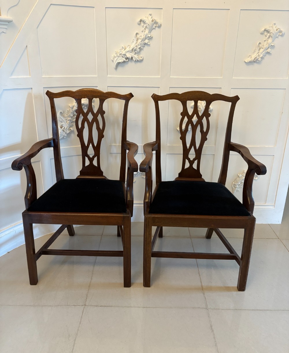 A set of eight Edwardian mahogany dining chairs with carved ribbon-pierced splats and black upholstered drop-in seats, including two armchairs. View IV