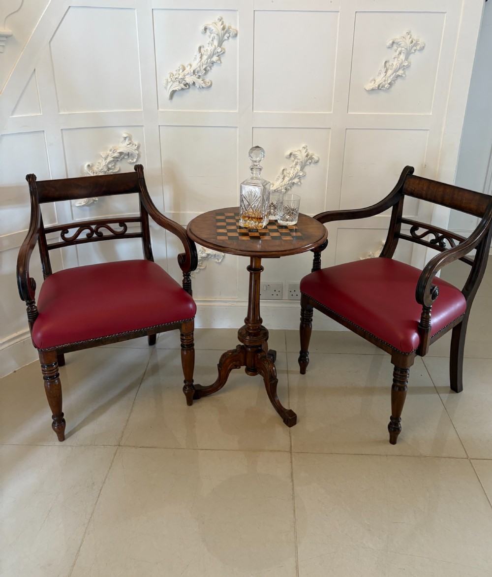 A pair of George III mahogany desk chairs featuring scroll arms, carved back splats, turned front legs, and red leather seats. View II