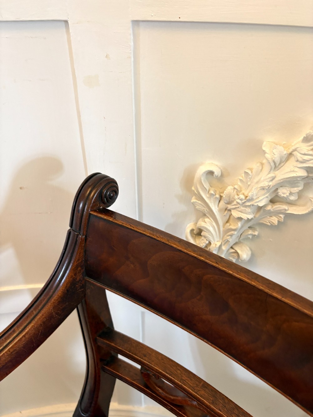 A pair of George III mahogany desk chairs featuring scroll arms, carved back splats, turned front legs, and red leather seats. View XII