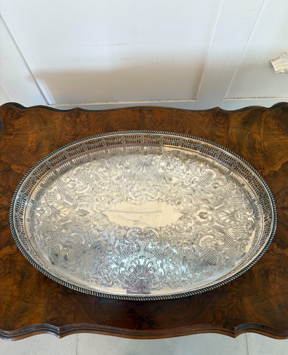An oval antique Edwardian silver-plated gallery tray featuring intricate floral surface chasing and a raised pierced rim. View VII