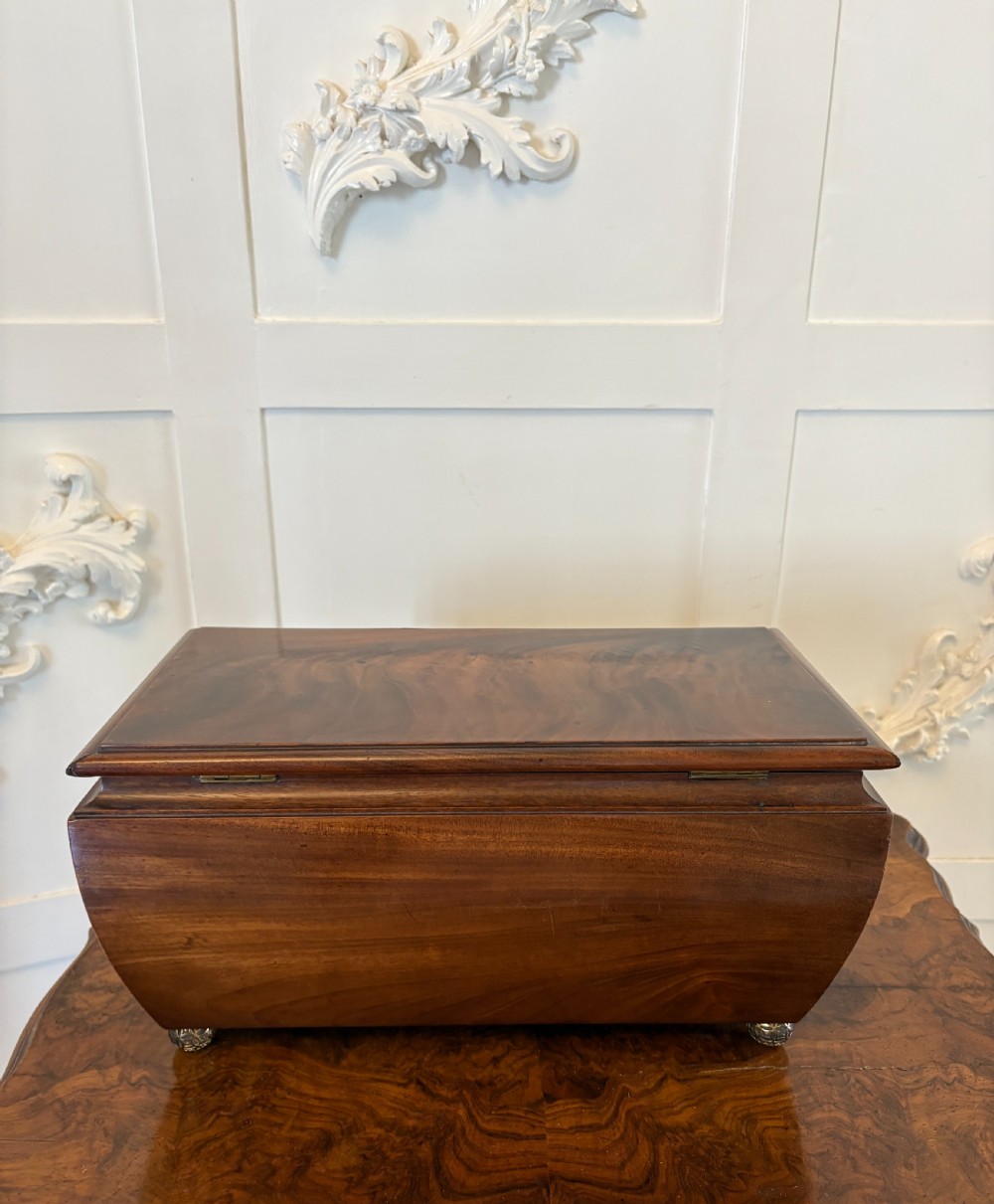 A Regency mahogany tea caddy featuring a hinged lid, tapered body, central escutcheon, and metal ball feet. View XIII