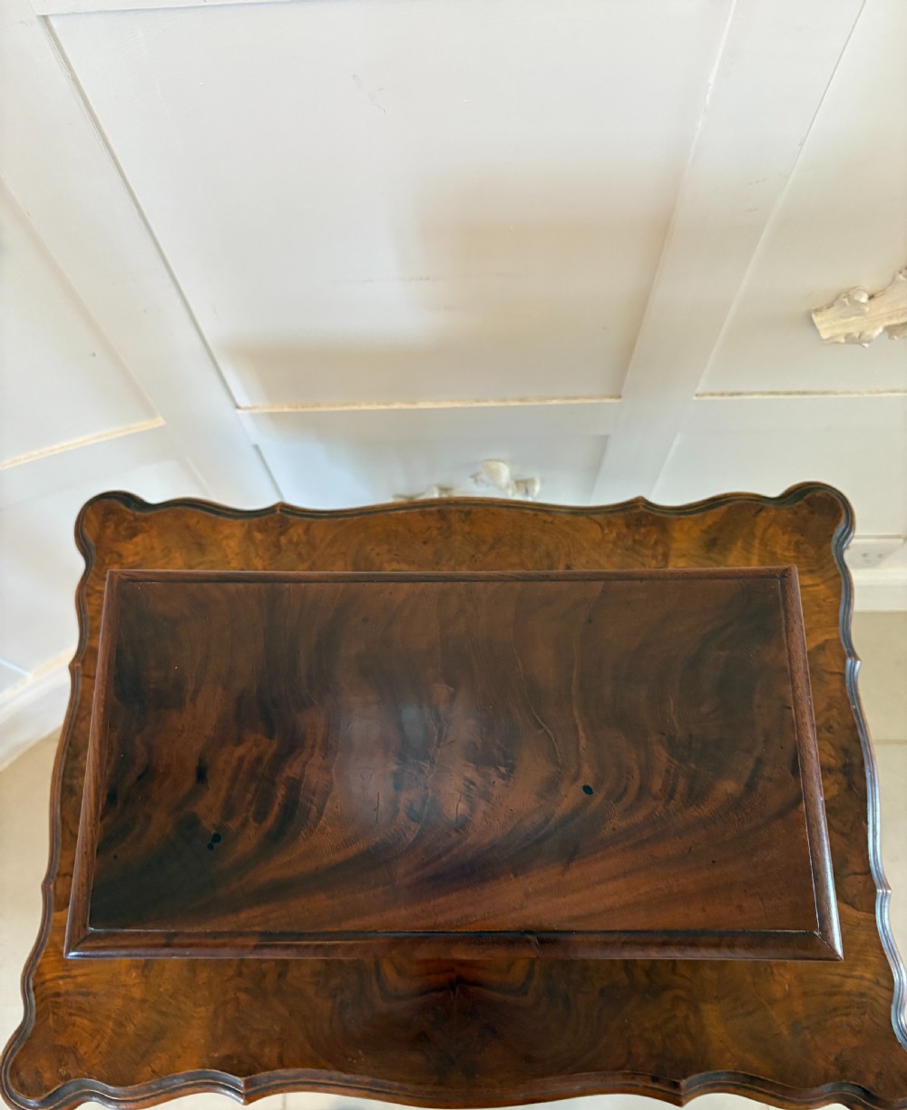 A Regency mahogany tea caddy featuring a hinged lid, tapered body, central escutcheon, and metal ball feet. View XIV
