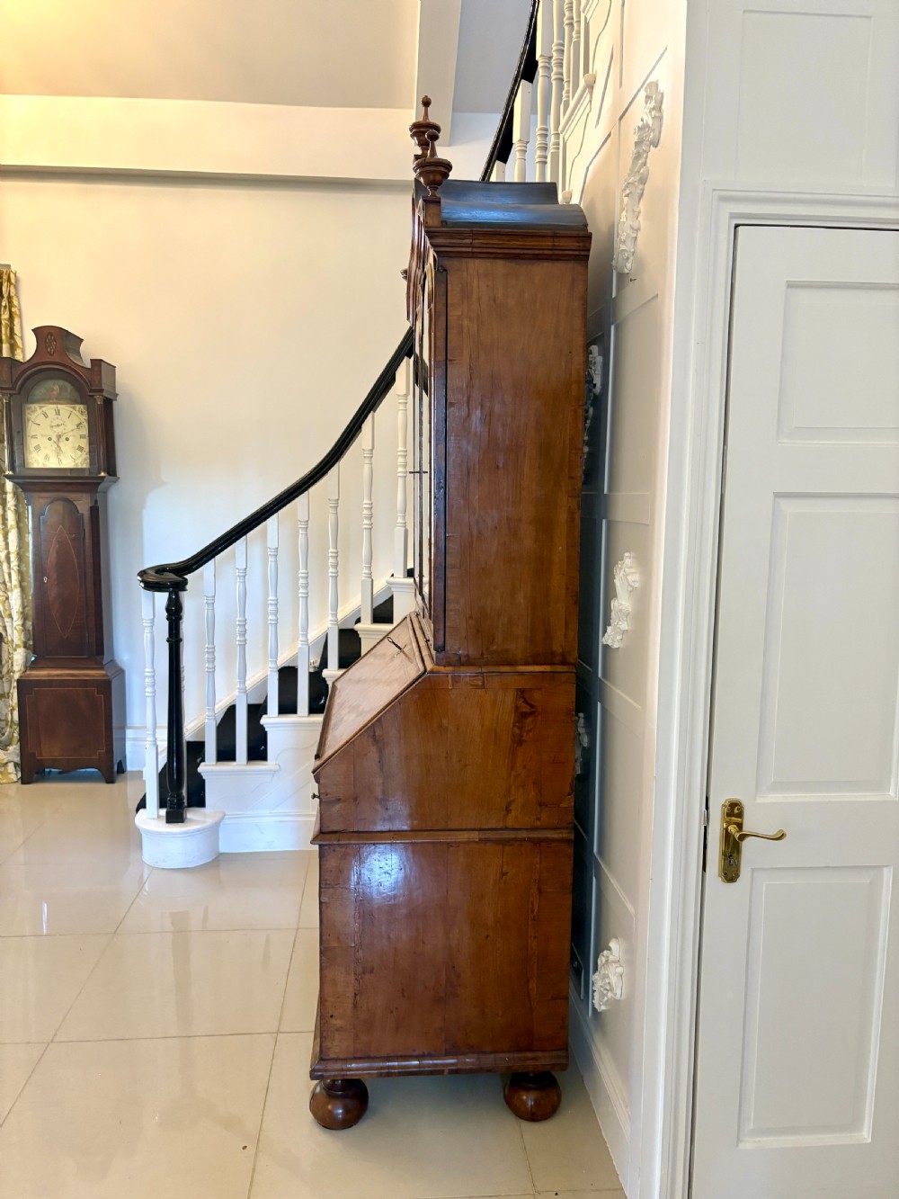 A Queen Anne style burr walnut bureau bookcase featuring a double-arched mirror door top section above a slant-front writing bureau and graduated drawers. View XIV