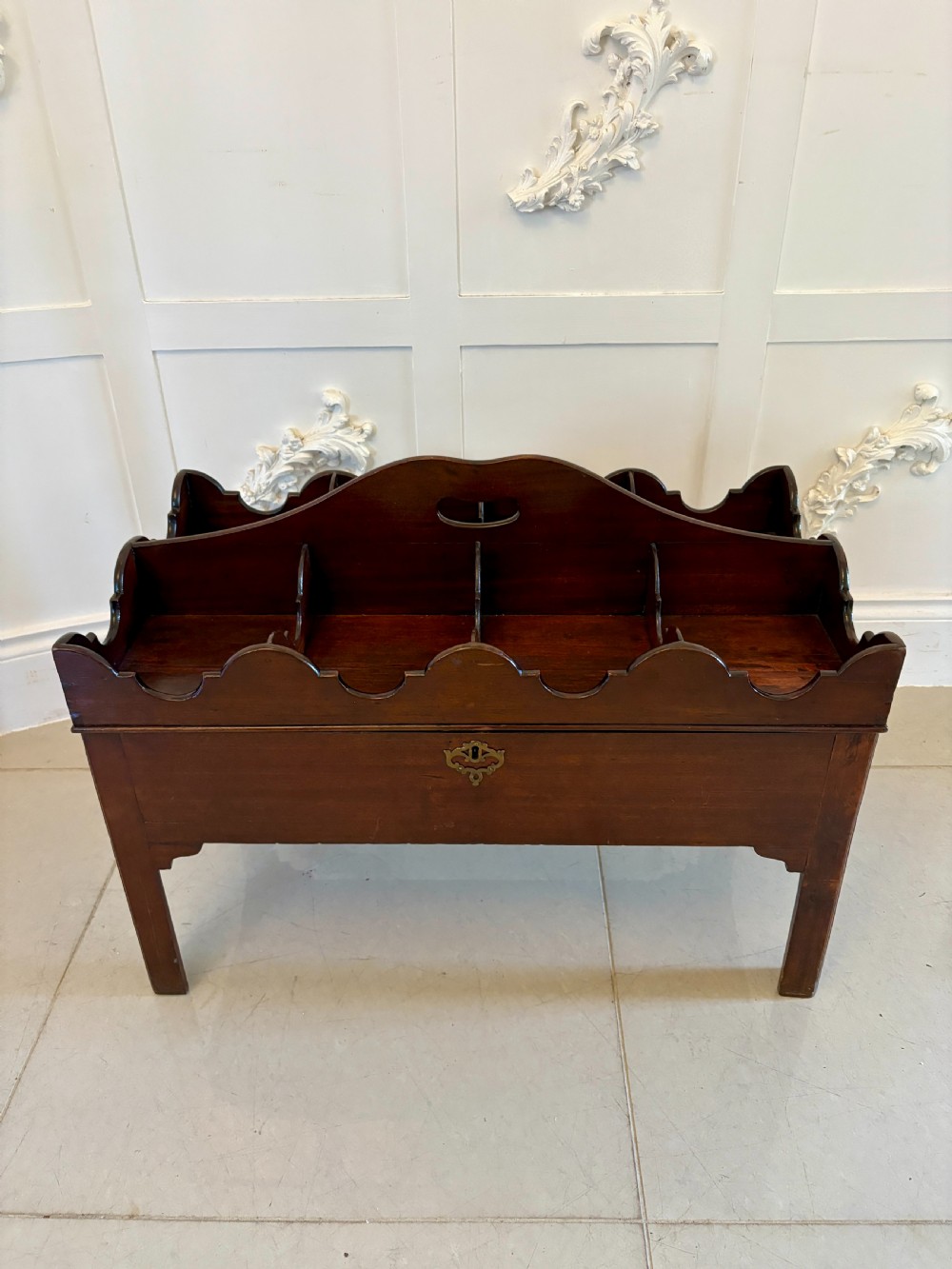 A George III mahogany freestanding bottle stand with a scalloped partitioned top gallery, central carrying handle, drawer, and square legs. View XIII