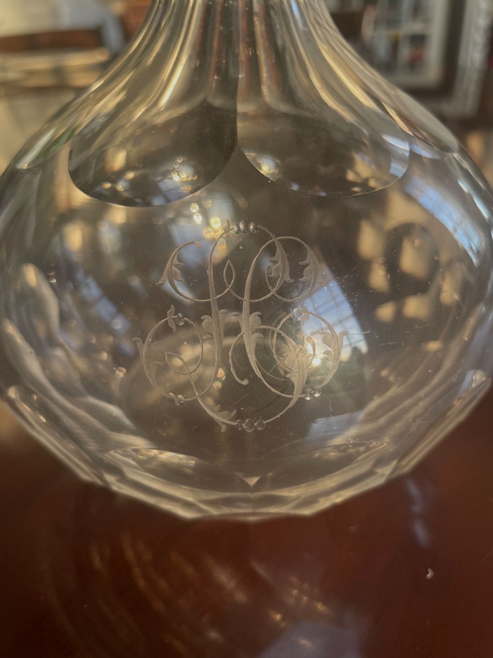 A matching pair of Victorian clear cut glass decanters featuring faceted stoppers, fluted necks, and geometric wheel-cut patterns on bulbous bases. View II