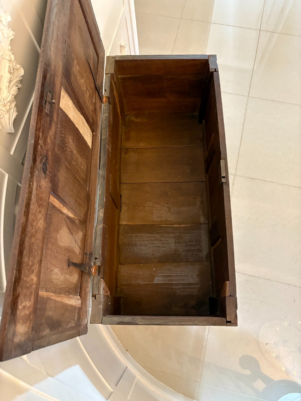 A seventeenth-century dark oak mule chest featuring a carved top frieze, geometric carved central panel, and two lower drawers with wooden turnings. View II