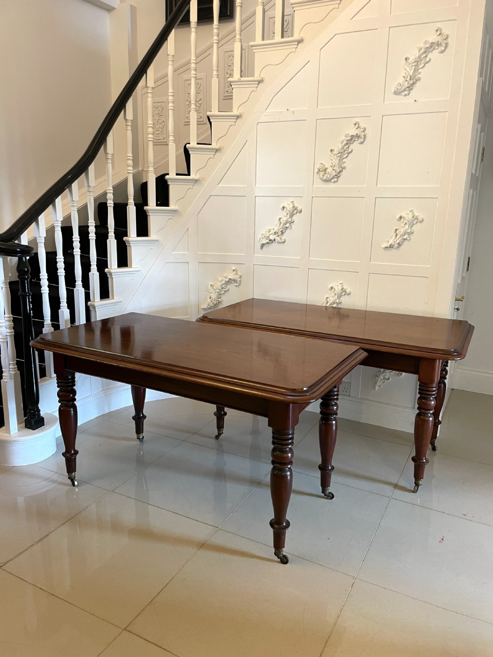 A large Victorian extending mahogany dining table featuring turned legs fitted with brass castors and a polished top with rounded corners. View IV