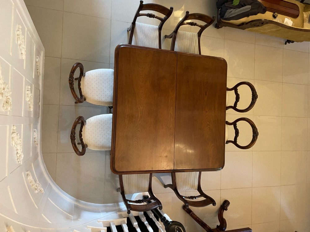 A large Victorian extending mahogany dining table featuring turned legs fitted with brass castors and a polished top with rounded corners. View V