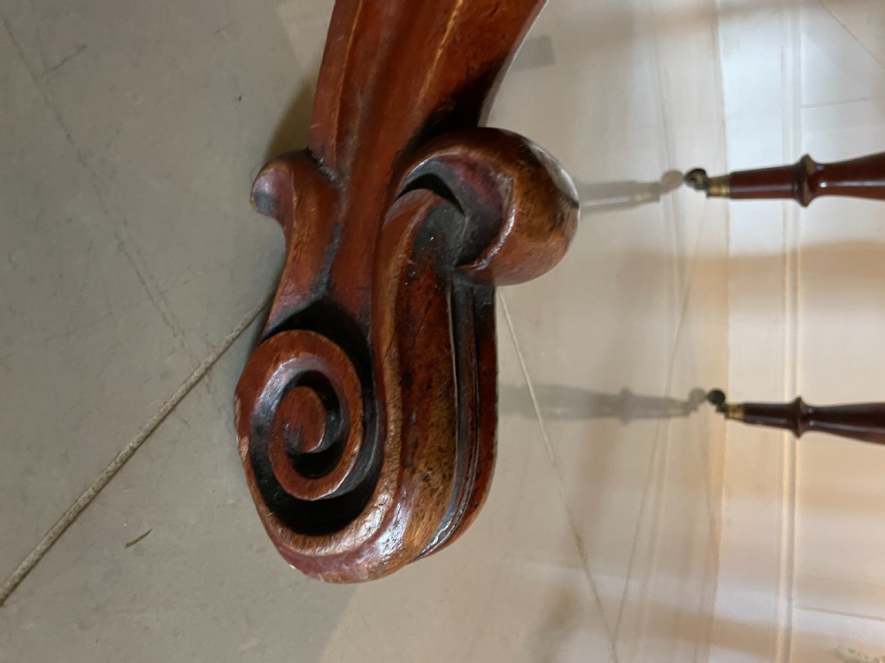 A large Victorian extending mahogany dining table featuring turned legs fitted with brass castors and a polished top with rounded corners. View XX