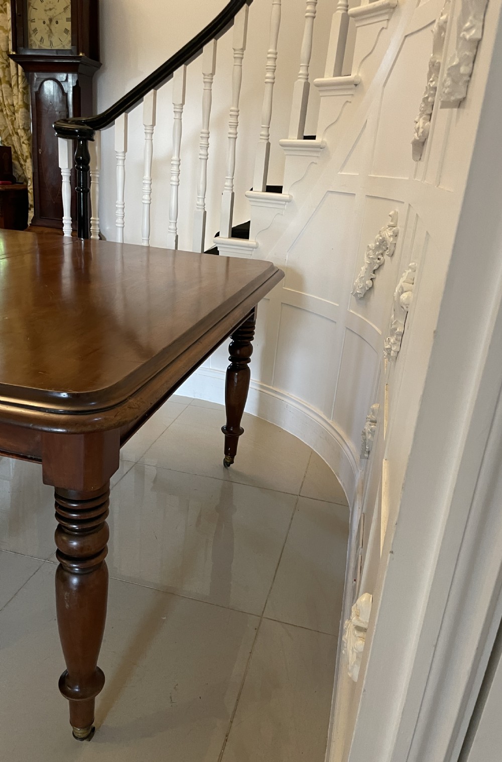 A large Victorian extending mahogany dining table featuring turned legs fitted with brass castors and a polished top with rounded corners. View XXVII