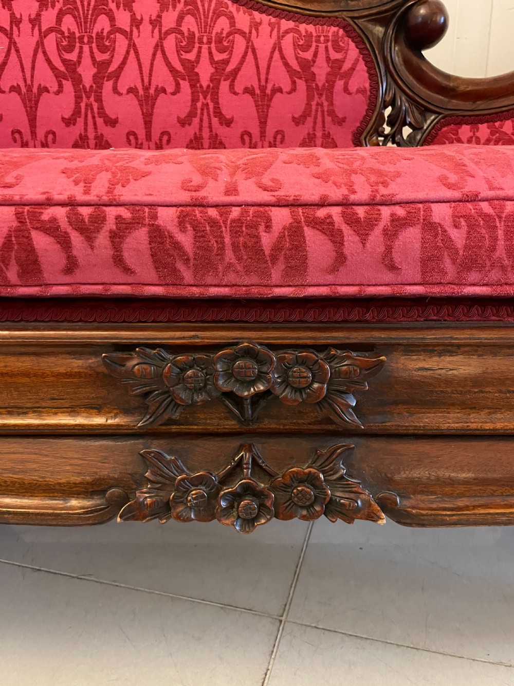 A Victorian carved mahogany chaise longue upholstered in patterned red damask fabric featuring an asymmetrical backrest and carved cabriole legs. View II