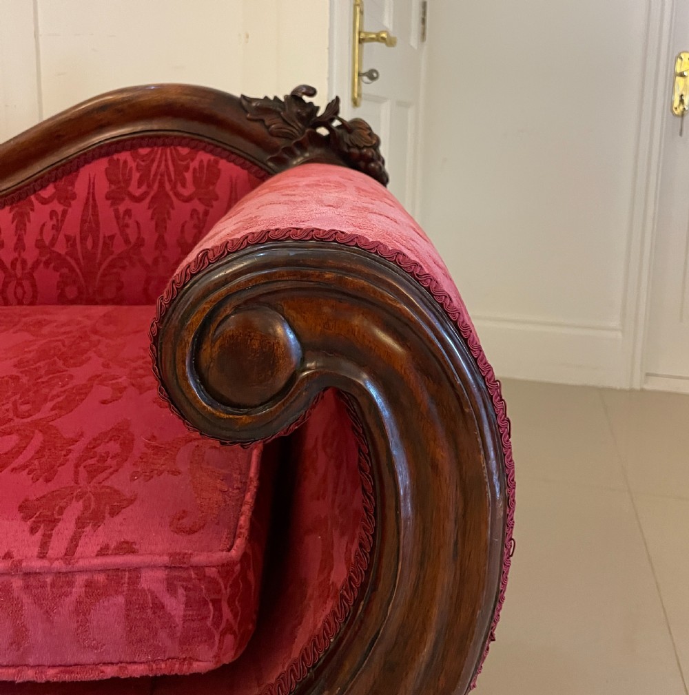 A Victorian carved mahogany chaise longue upholstered in patterned red damask fabric featuring an asymmetrical backrest and carved cabriole legs. View IV